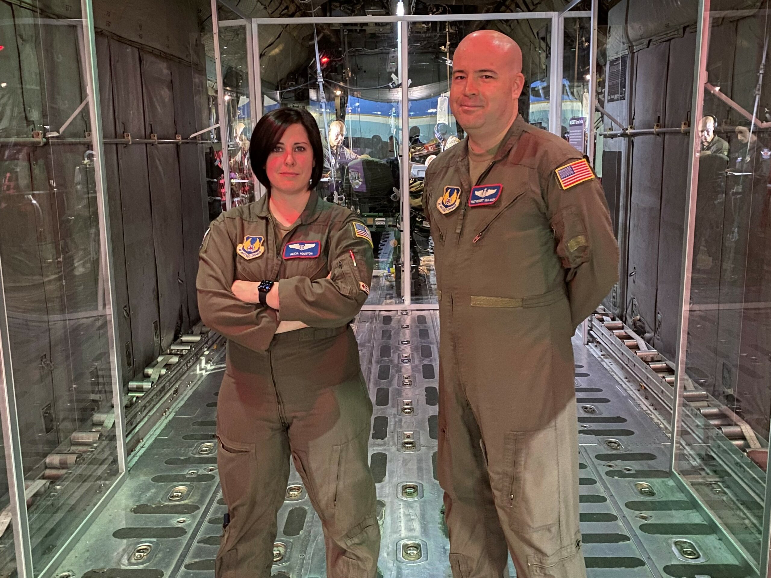 Tech Sgt. Robert Van Aken and Capt. Alicia Houston standing in front of the Transport Isolation System (TIS)